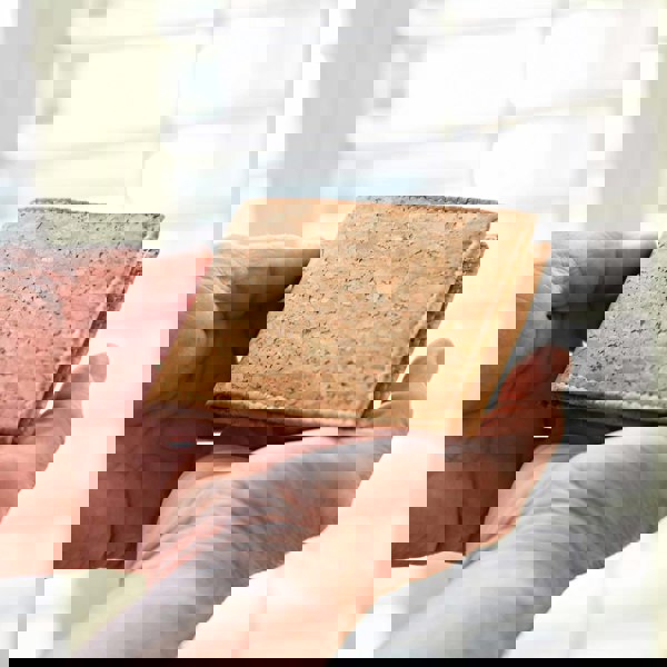 A Natural Cork Billfold Wallet securely grasped by a man's hand.
