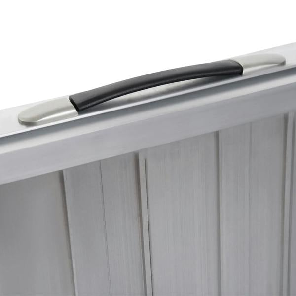 Aluminum folding wheelchair ramp with black carry handle on folded side panel