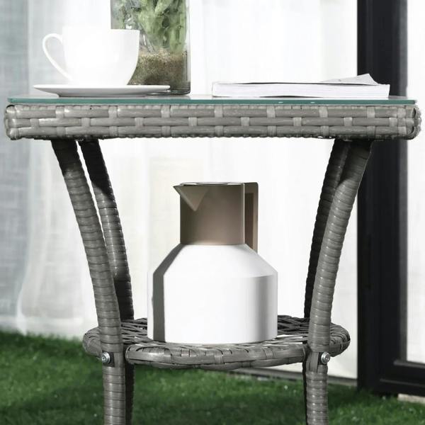 Grey woven rattan coffee table with glass top and lower shelf with storage box