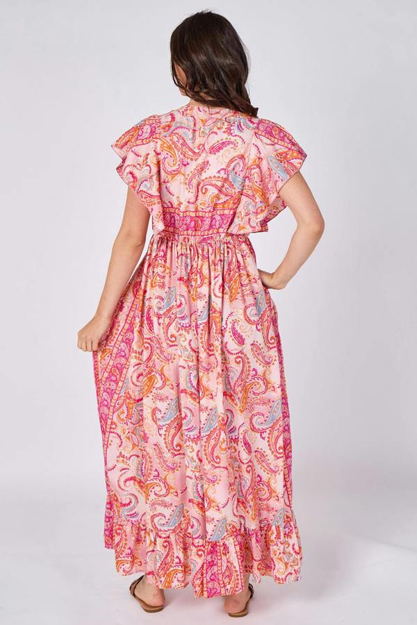 Woman wearing a pink and orange patterned dress on a white background