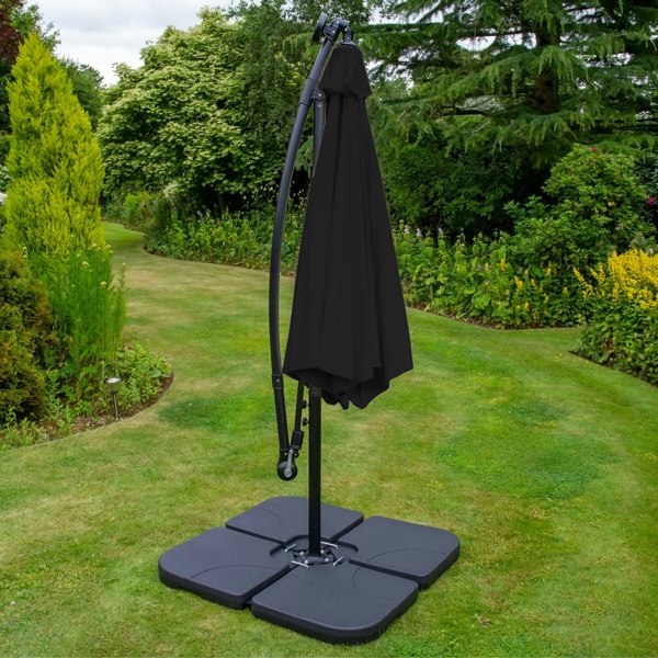Anthracite 4 piece sofa set with a sleek black parasol and sturdy base, set in a lush garden with vibrant greenery and soft grass