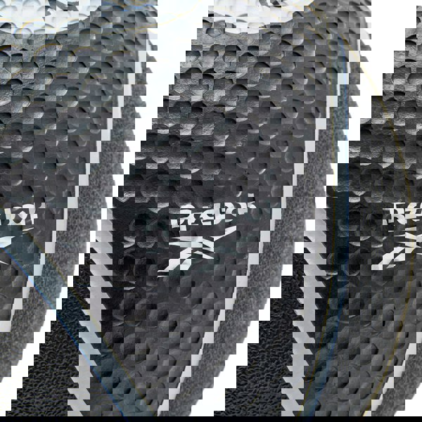 Close-up of a Reebok logo on a textured medicine ball surface