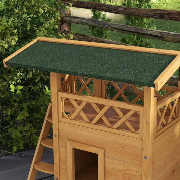 Outdoor wooden cat house close-up: green roof, balcony lattice panel, and square door opening