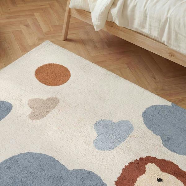 Children's rug with colorful animal shapes on a wooden floor.