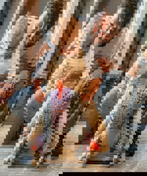 Little boy with his dad, sitting on a rocking dinosaur