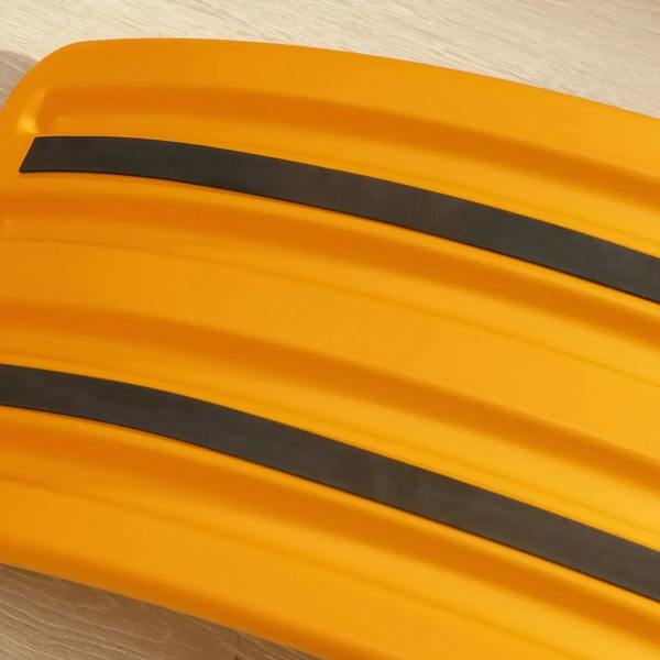 Orange balance board with black anti-slip strips, close-up underside detail