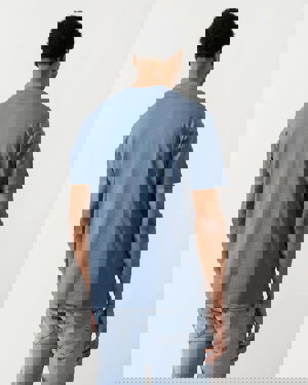 rear view of a Model wearing an Armani Exchange Mens T-Shirt with Tonal Milano/New York Logo in China Blue U9302