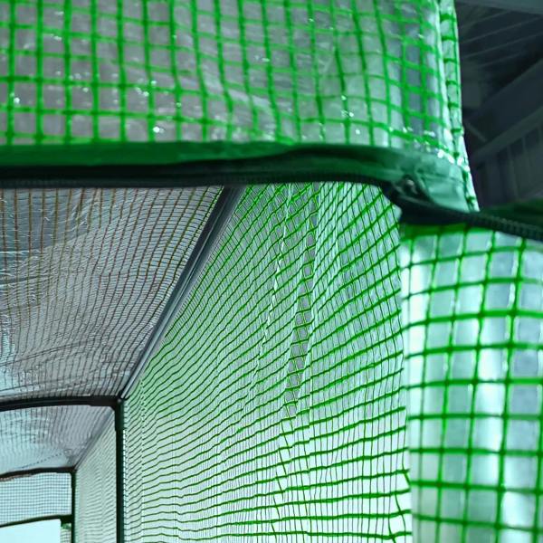 Close-up of green PE mesh greenhouse cover and arched frame near the door seam
