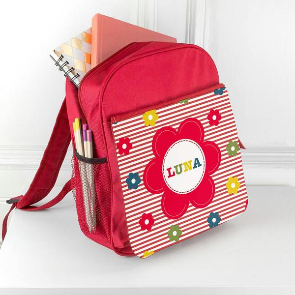 Personalised bright red girl's mini rucksack custom-printed with the name Luna, filled with notebooks and pencils in the side mesh pocket.