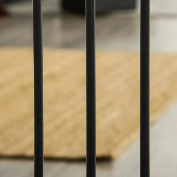 Black pet safety gate vertical bars close-up with base frame feet visible