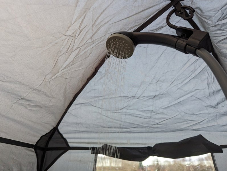 The USB Batter Shower hooked inside an OLPRO Shower Tent.