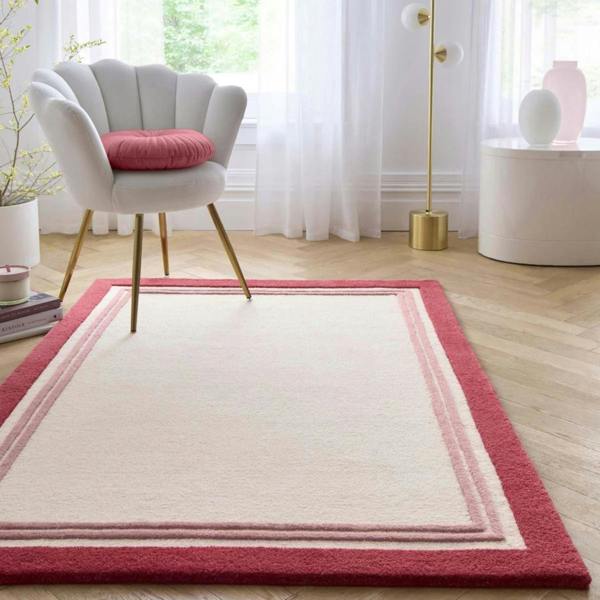 Pink and white area rug with a chair and decorative elements in a room.