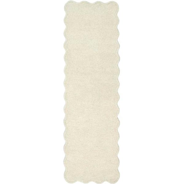 Rectangular white rug with scalloped edge on a white background