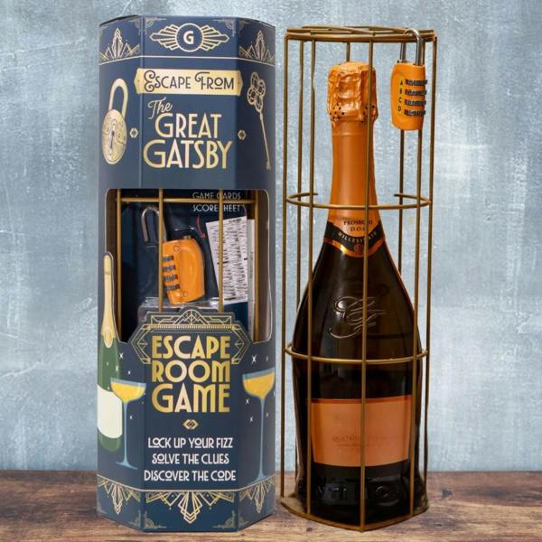 A tall, blue hexagonal box titled "Escape from The Great Gatsby Escape Room Game" standing next to a bottle of Prosecco secured inside a gold-colored metal cage with an orange combination padlock attached.