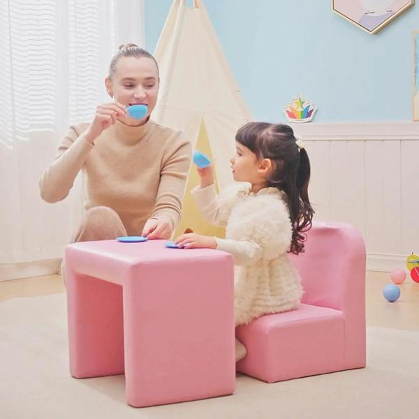 Pink toddler sofa chair with matching low cube table, children playing indoors