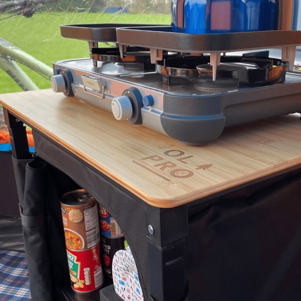 The OLPRO Bamboo Cooking Table with plates, cutlery and food in it in a campervan awning.