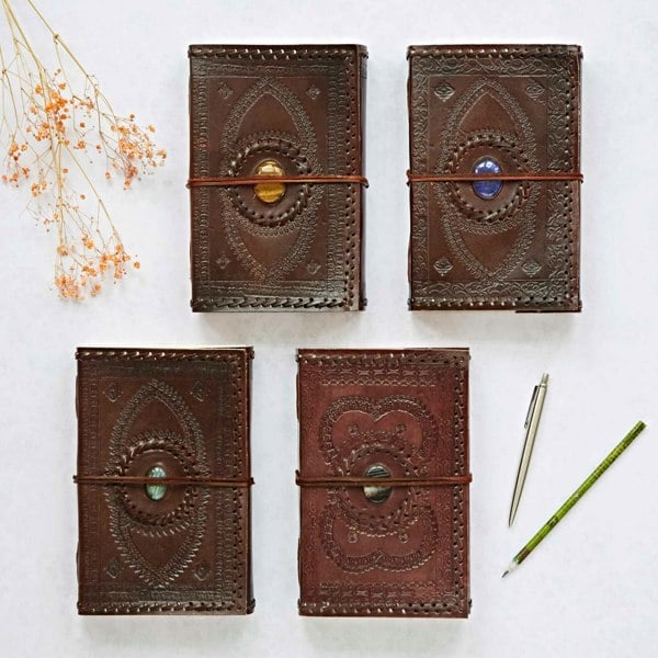 Four journals and a pen featuring Indra, extra large size, embossed and stitched leather covers adorned with semi-precious stones. Available in lapis, tiger's eye, labradorite and black onyx.