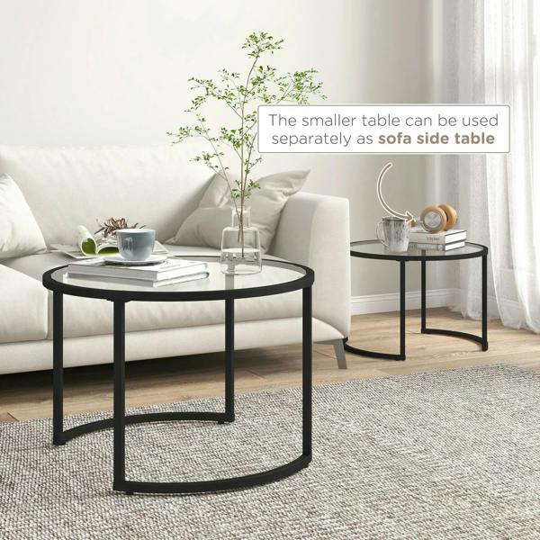 Black round nesting coffee tables; smaller glass-top table tucks under larger tabletop.