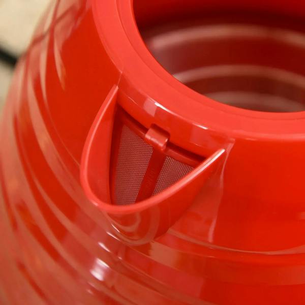 Close-up of a glossy red kettle spout with mesh filter