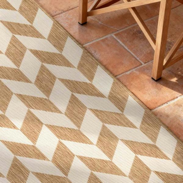 Geometric patterned rug on a terracotta tiled floor with wooden furniture.