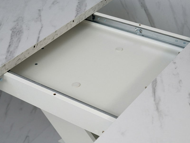 Detail of the extending table system concealed beneath the White Bianco marble effect top