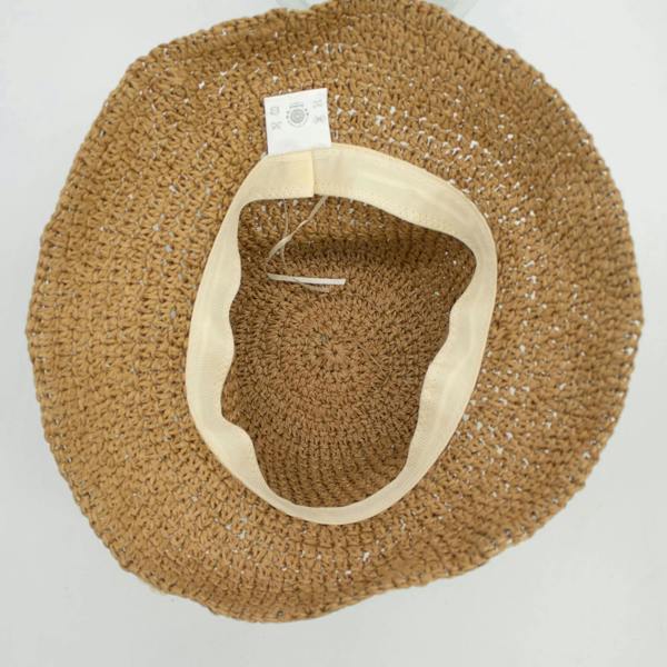 Inside view of straw floppy hat with light ribbon band and attached inner tag