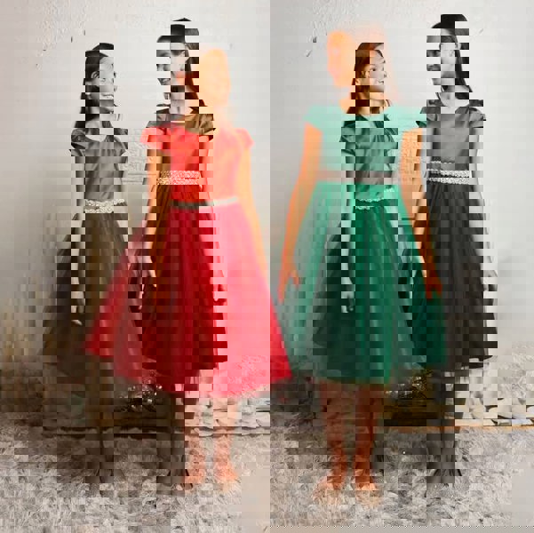 Two girls smiling holding dresses