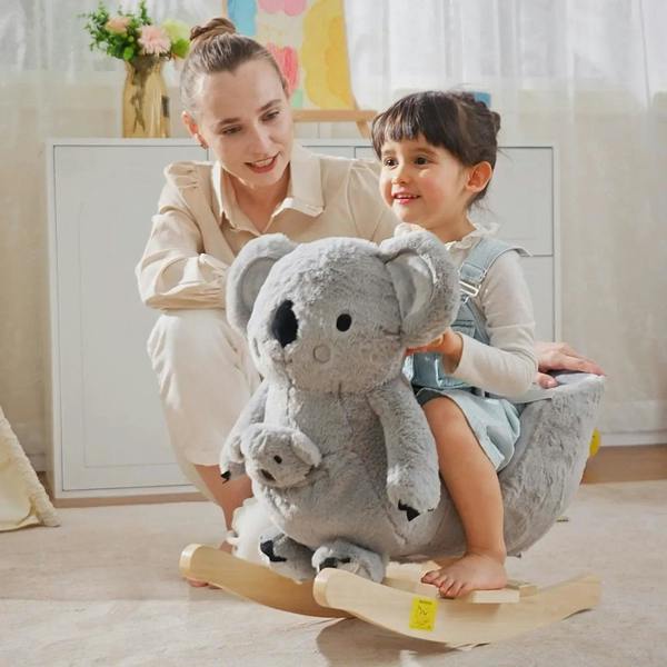 Gray koala plush rocking horse with gloved doll on wooden rocker base, toddler seated