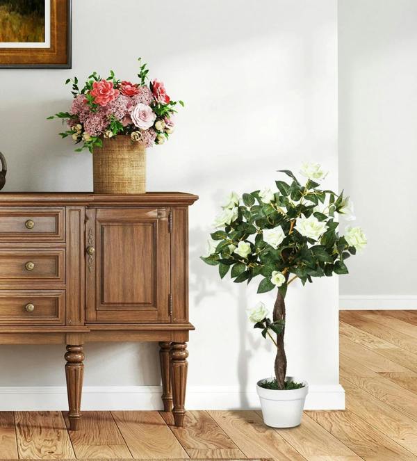 Artificial white rose floral plant with white blooms, green leaves, and brown trunk in pot
