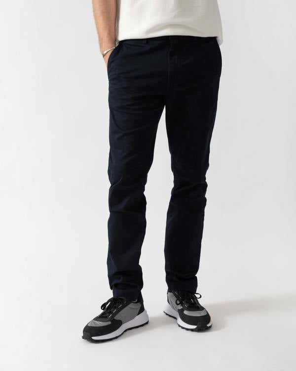 studio shot of a model wearing Lacoste Slim Fit Stretch Cotton Mens Chinos in Abysm HDE