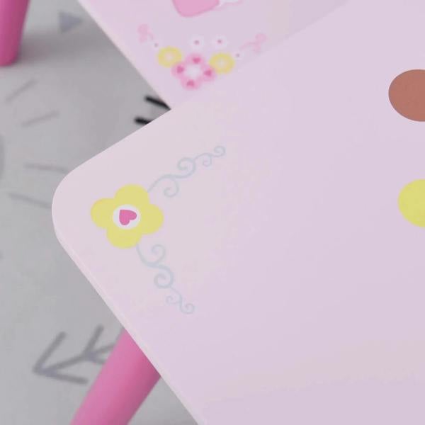 Close-up of white kids table corner with princess crown and hearts print, pink leg