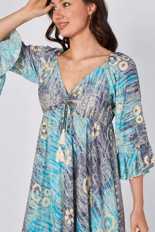 Woman wearing a patterned dress with a plain background