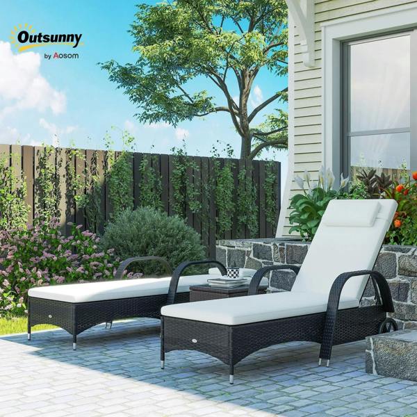 Black rattan sun lounger with white cushion, outdoor patio terrace view