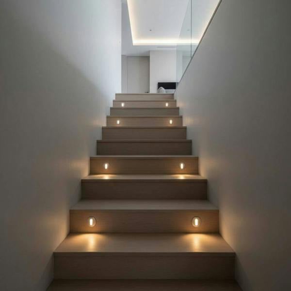 silver recessed step light shown installed into wooden stair risers 