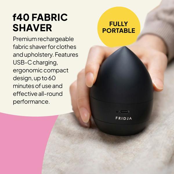 A hand holds the Fridja Commercial Garment Care Duo – f1600 Steamer & f40 Fabric Shaver, featuring a rechargeable, portable design with USB-C charging, ergonomic shape, and up to 60 minutes of care for clothes and upholstery.