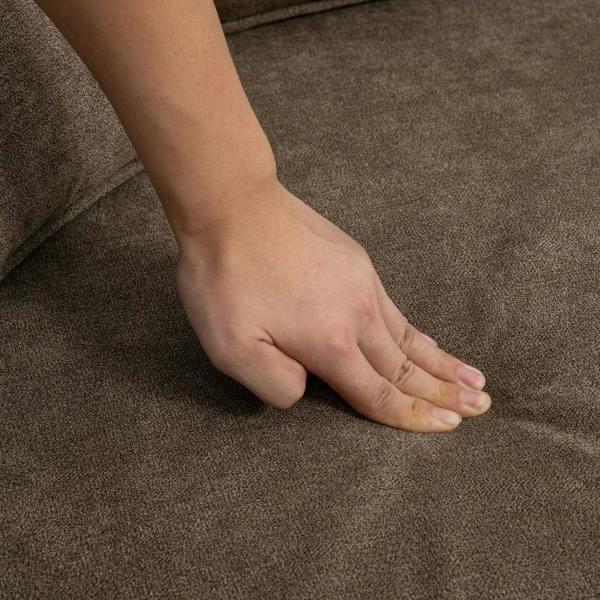 Brown fabric sofa seat cushion with a hand resting on the upholstery
