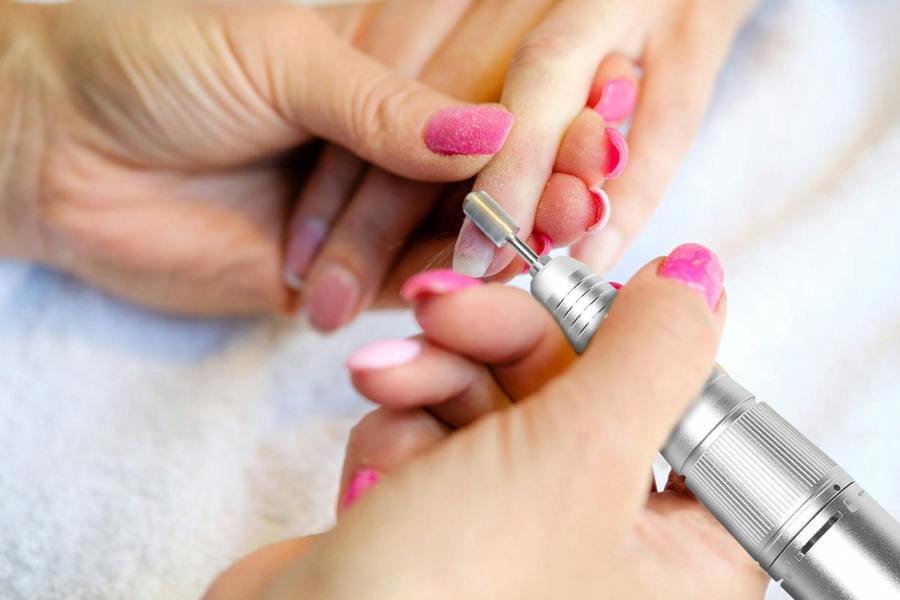 salon electric nail file being used in nail salon to file down nails