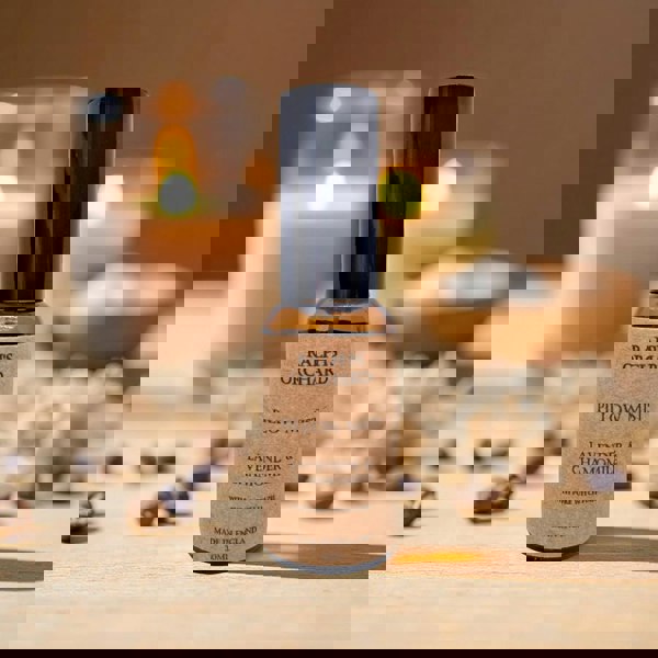 Ralph's Orchard pillow mist bottle with candles and flowers in the background