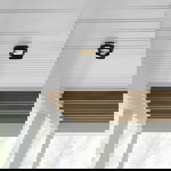 black outdoor downlight mounted under a house porch 