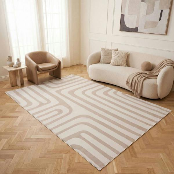 Living room with a beige sofa, armchair, and abstract painting on a light wood floor.