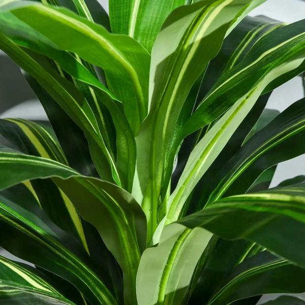 Close-up of artificial green leaves with striped texture on a potted plant