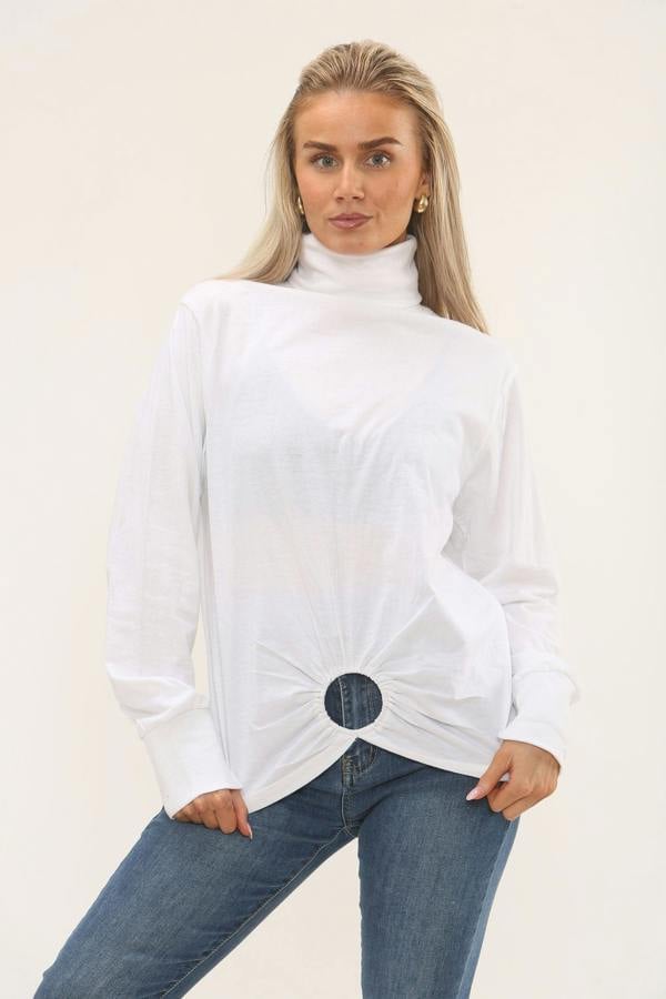 Woman wearing a white turtleneck sweater and blue jeans on a beige background