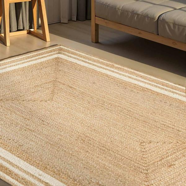 Close-up of a woven beige rug with a wooden chair and sofa in the background.