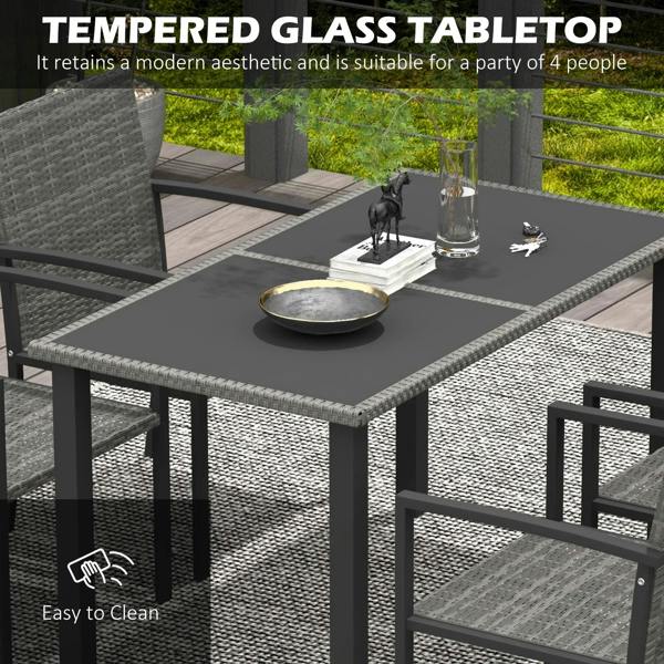 Close-up of grey dining table with dark tempered glass top and woven chair seating