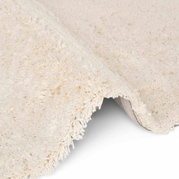 Close-up of a textured beige rug corner on a white background