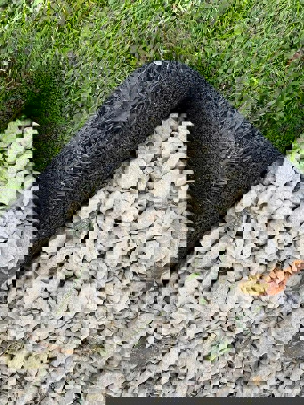 Black Flexiborder in a garden edging the lawn and stones
