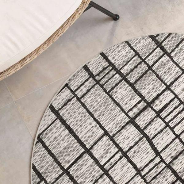 Round geometric patterned rug on a tiled floor