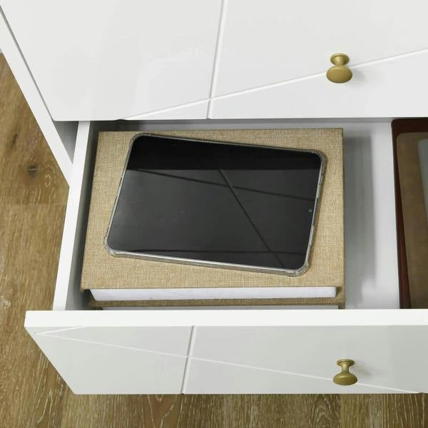 Open drawer in white tall dresser with gold knob, showing fabric-lined organizer inside.
