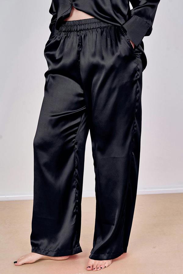Black satin pajama set on a plain background