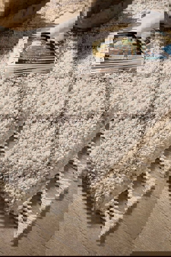 Moroccan style rug in soft cream and grey with tassels, perfect for adding charm to modern decor.